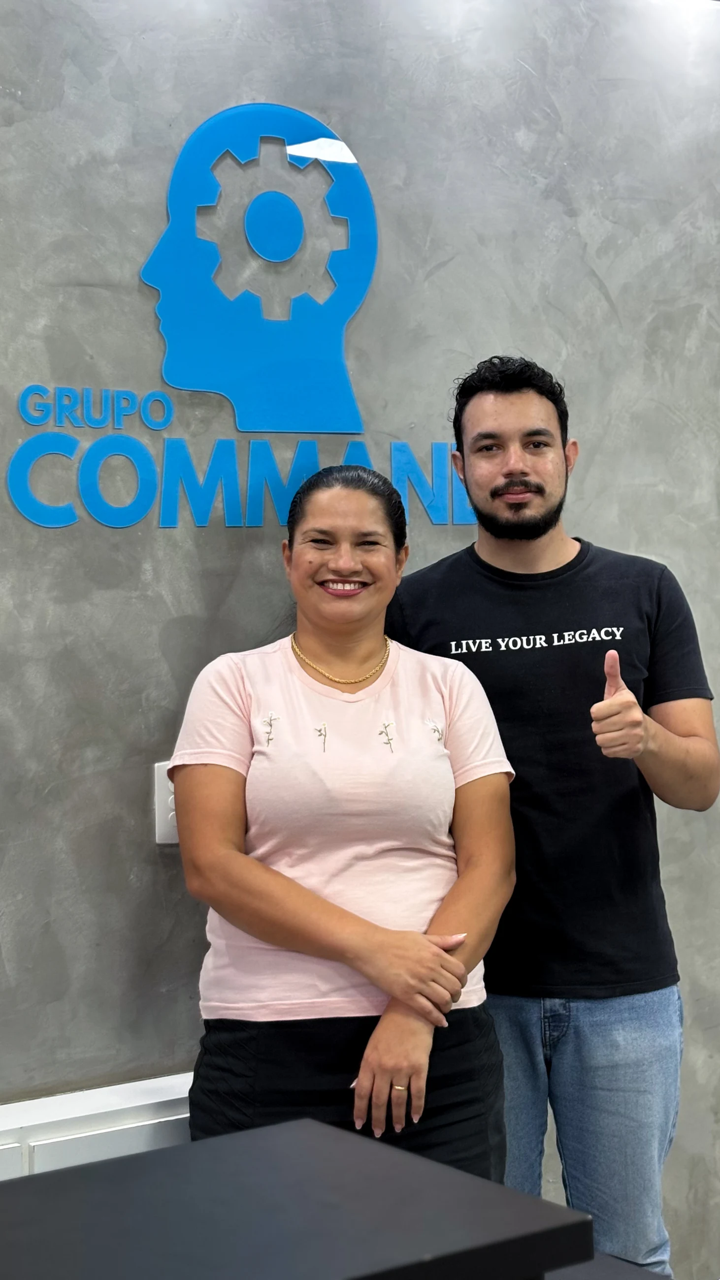 Duas pessoas diante da marca do Grupo COMMAND.
