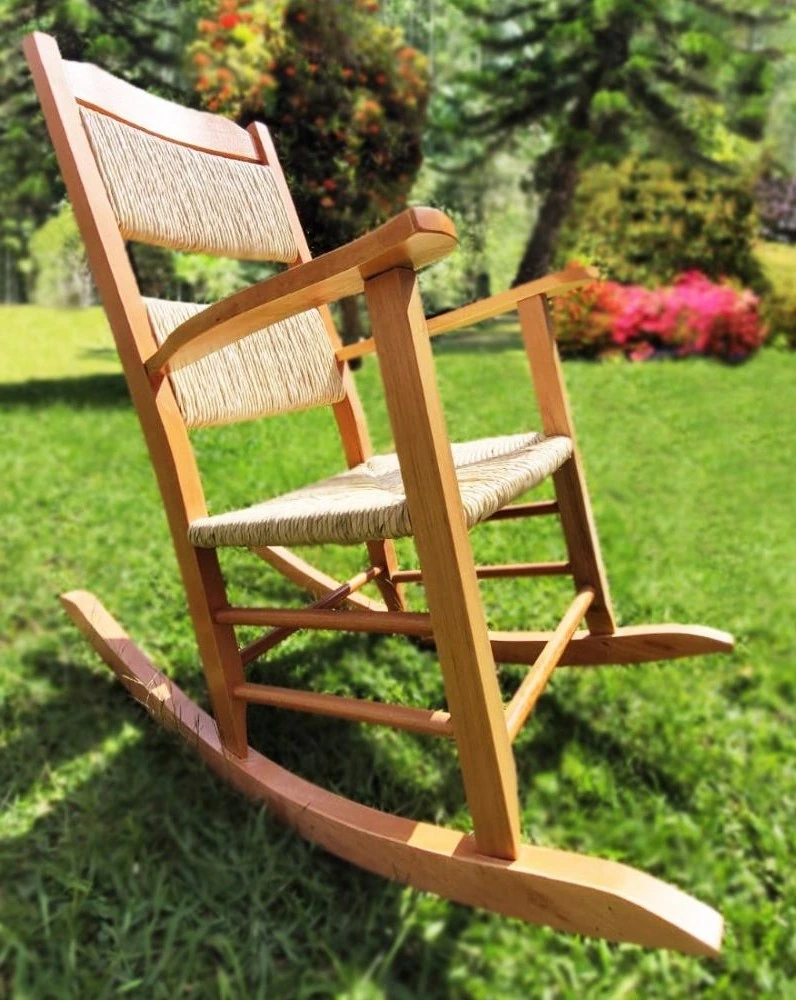 Cadeira de balanço Trento em madeira e palha no jardim