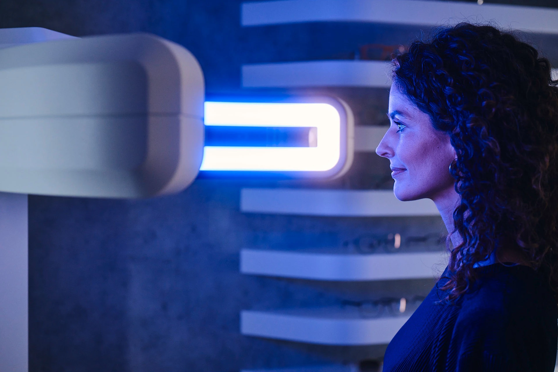 Mulher acompanha uma medição em um equipamento ZEISS iluminado.