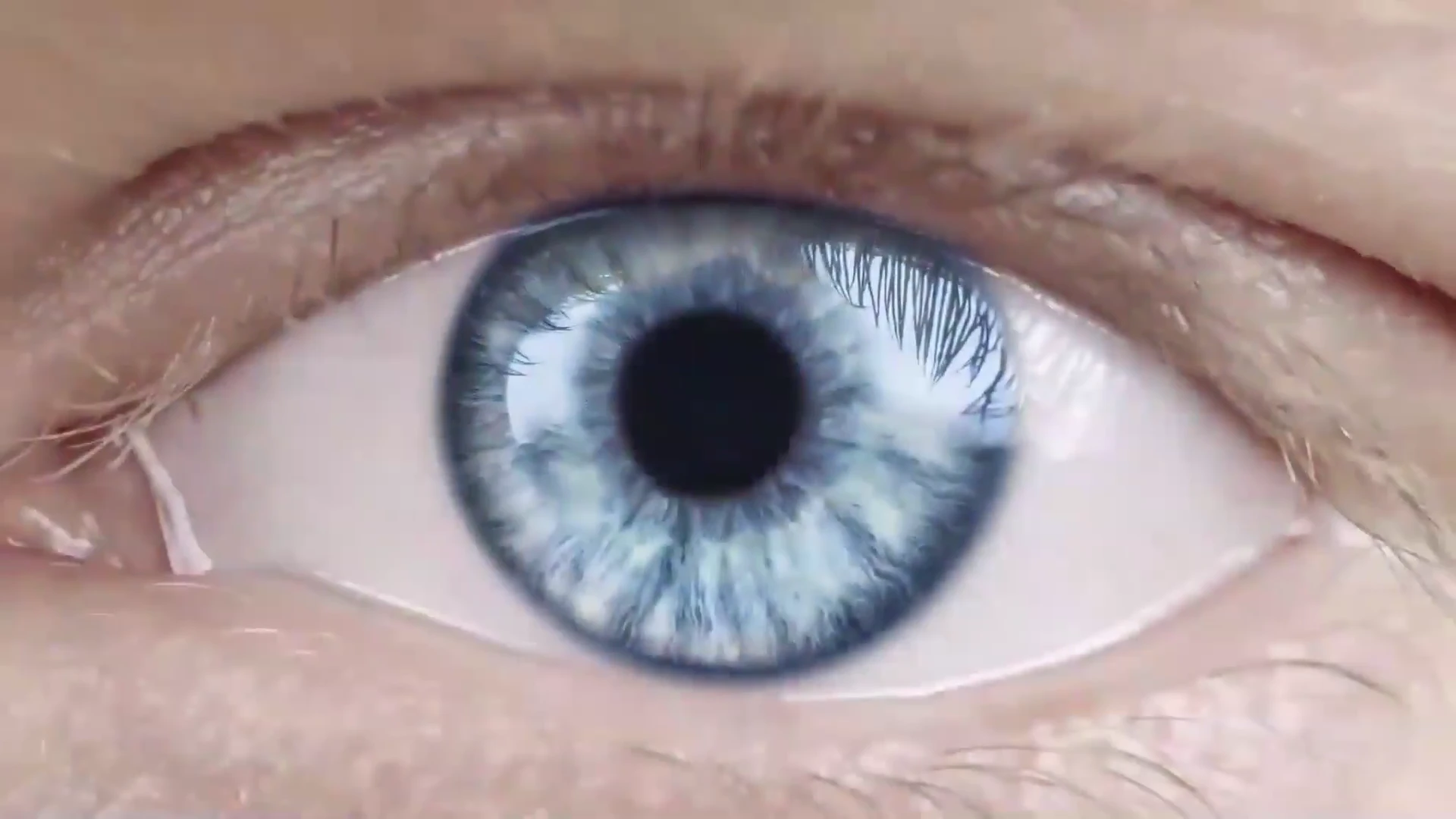 Íris azul vista de perto, com seus detalhes naturais.