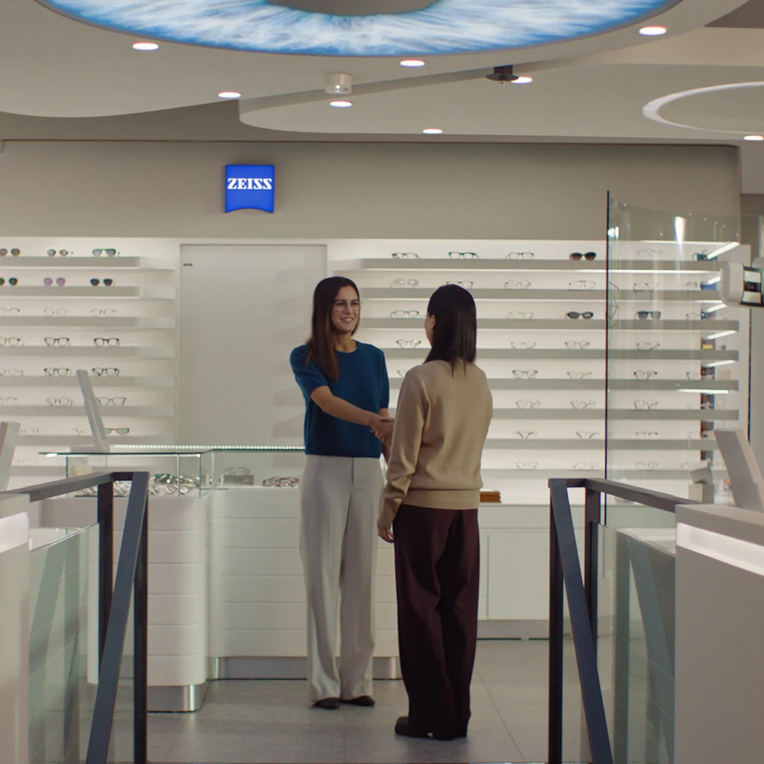 Atendimento em um ambiente ZEISS Vision Center, com exposição de armações.